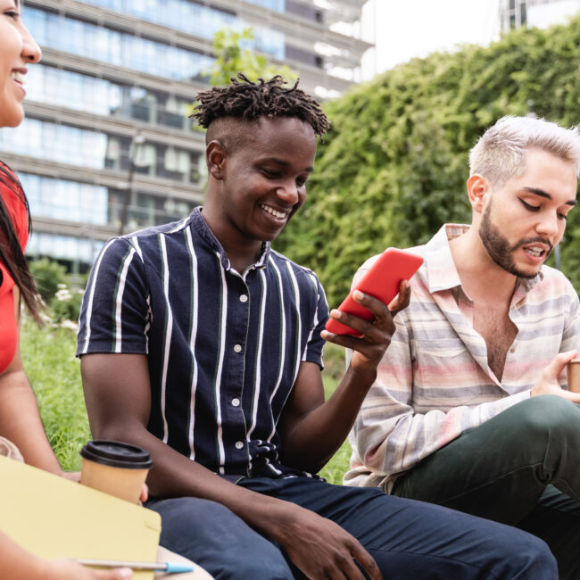 Diverse people having fun eating takeaway food outdoor in the city - Focus on non-binary man